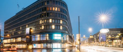 Helsinki, Finland. Hotel And Shopping Center On Crossroad Of Kaivokatu Street And Mannerheimintie Or Mannerheim Avenue In Evening Or Night Illumination.